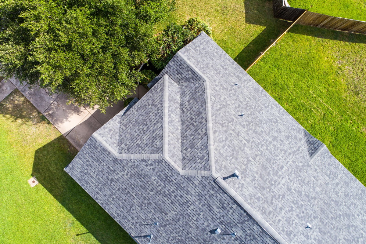 A drone shot looking straight down on the rooftop of a single home in a neighborhood